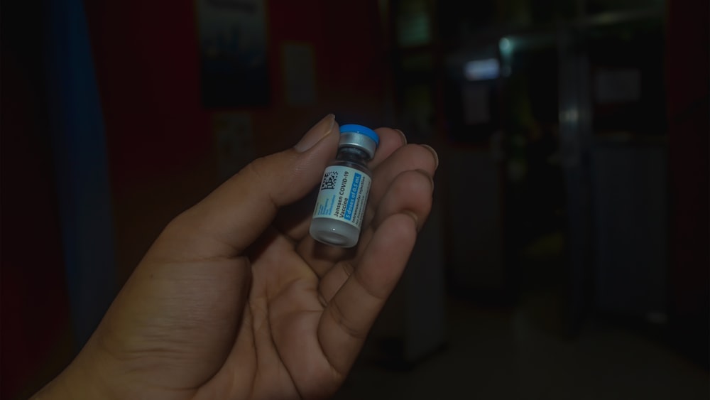 person holding blue and white bottle