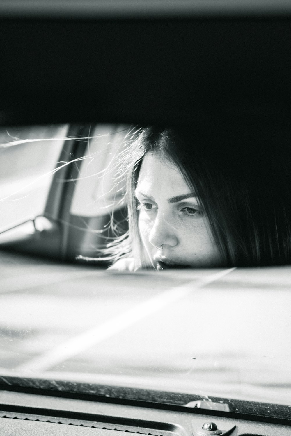 a woman looking out the window of a car