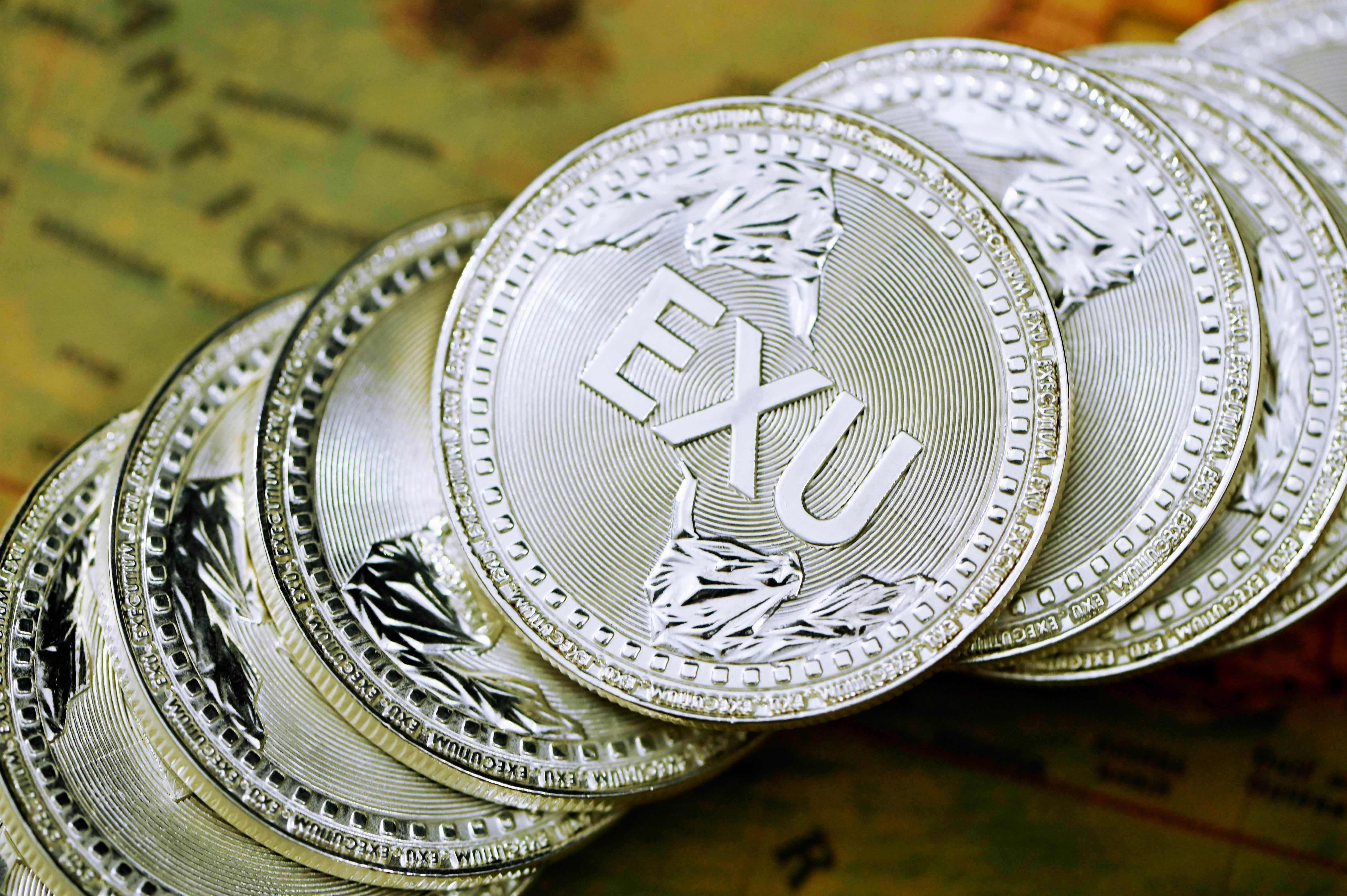 silver round coin on brown wooden table