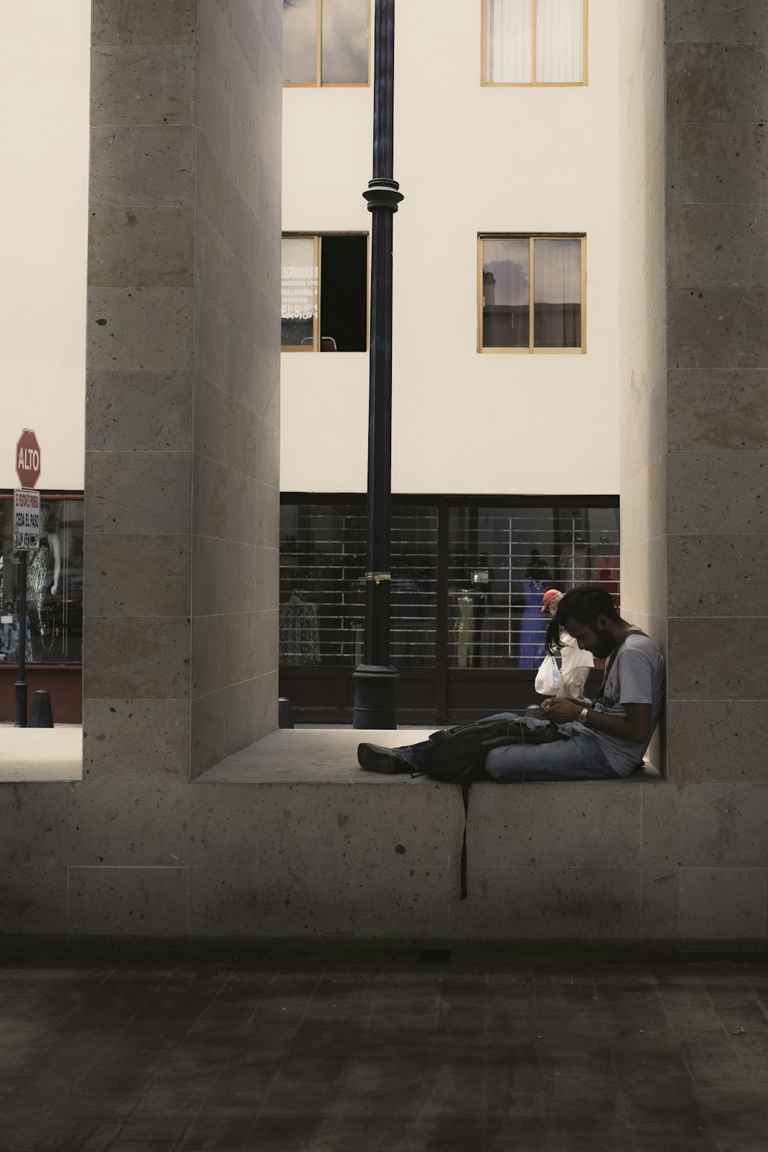 man and woman sitting on concrete bench during daytime