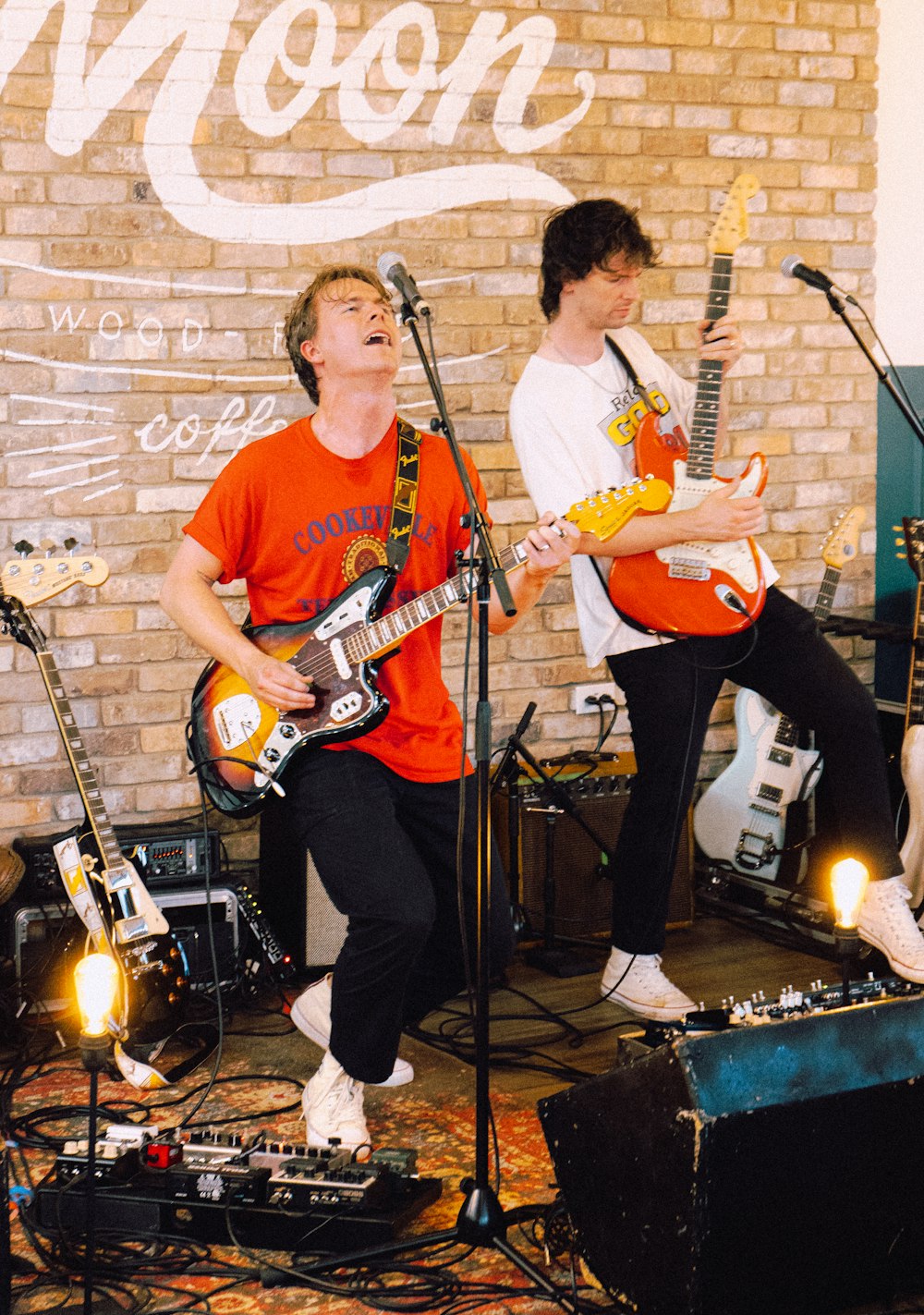 man in red crew neck t-shirt playing electric guitar