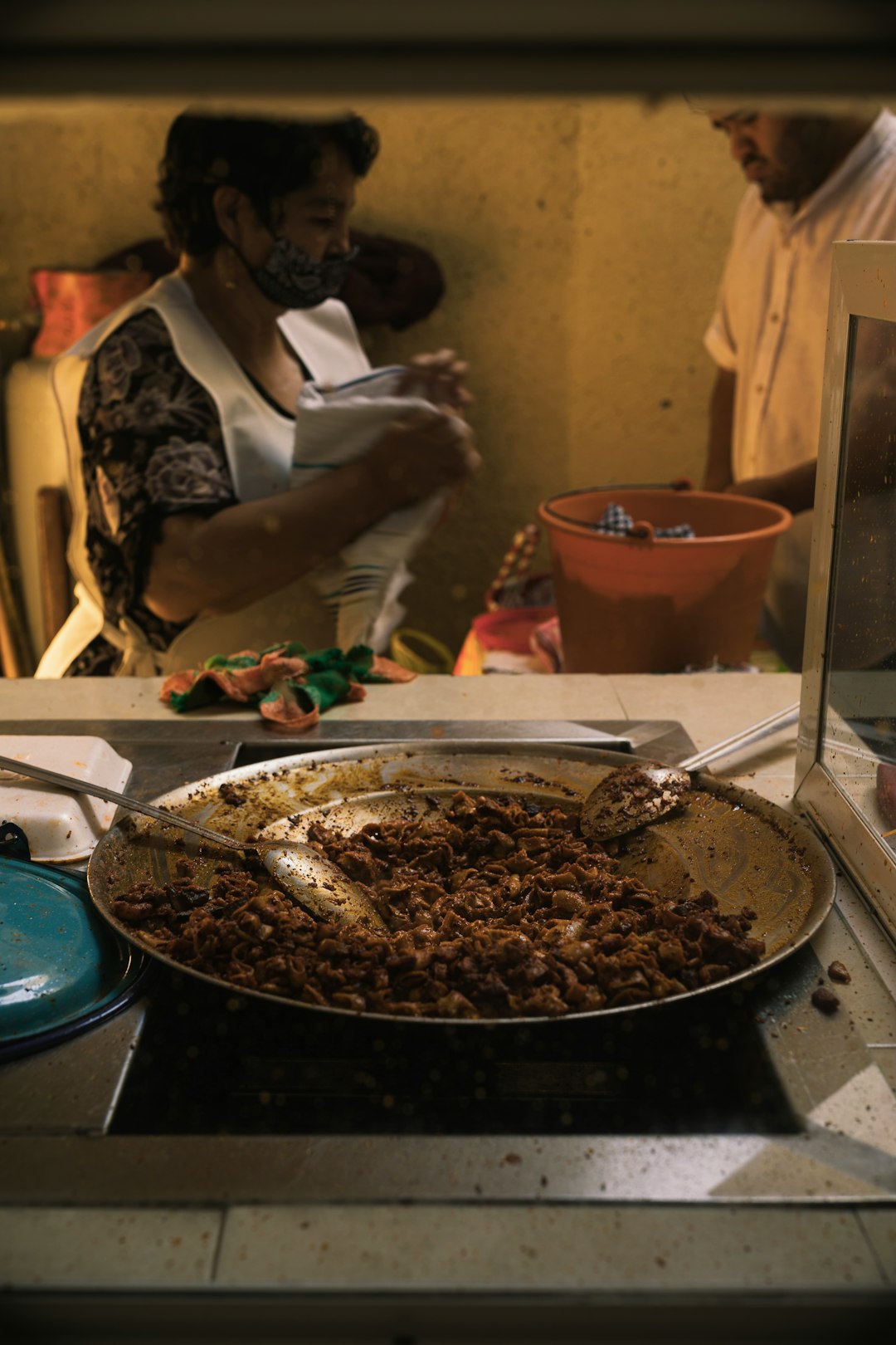 person in white apron holding stainless steel bowl