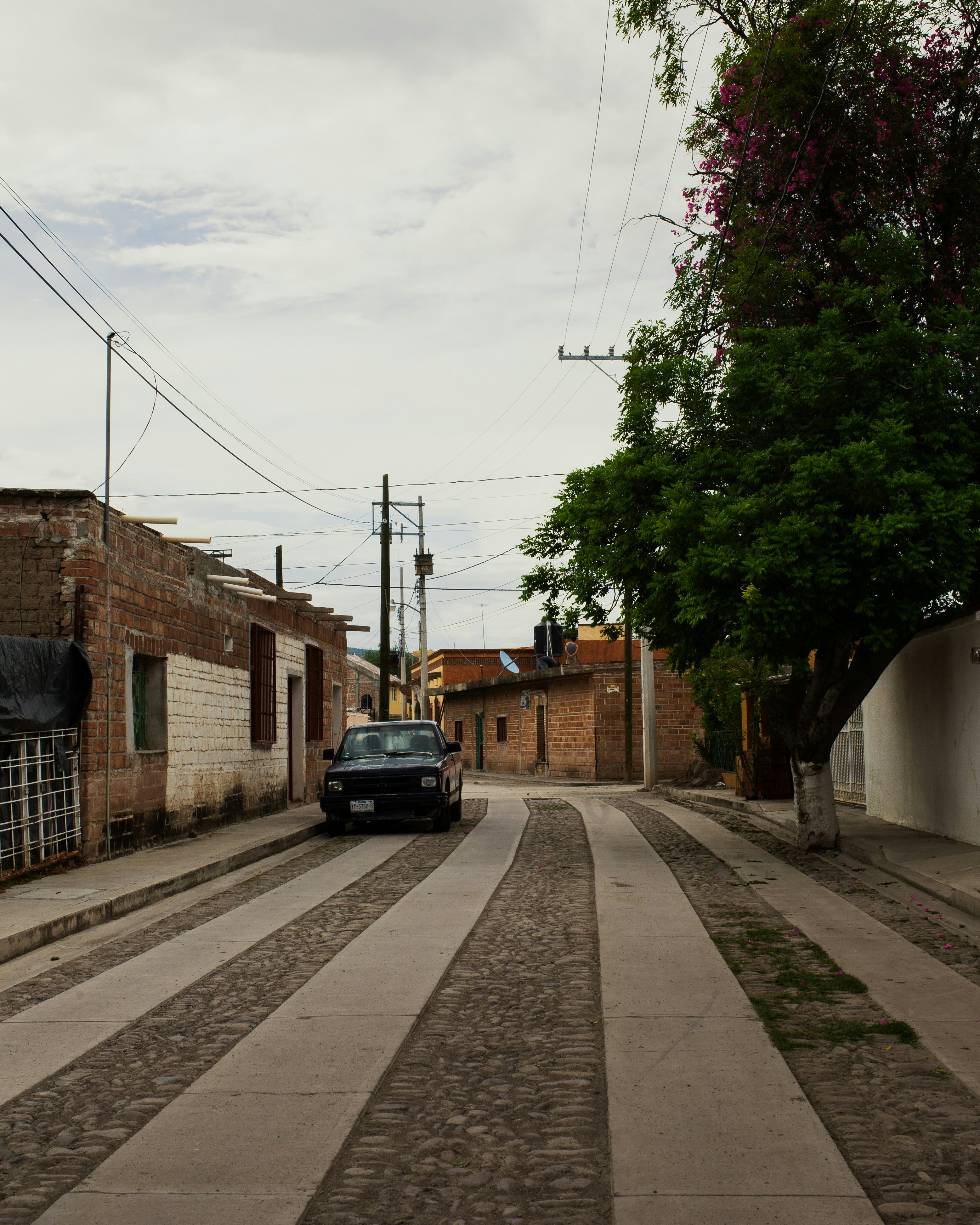 black car parked beside brown brick building