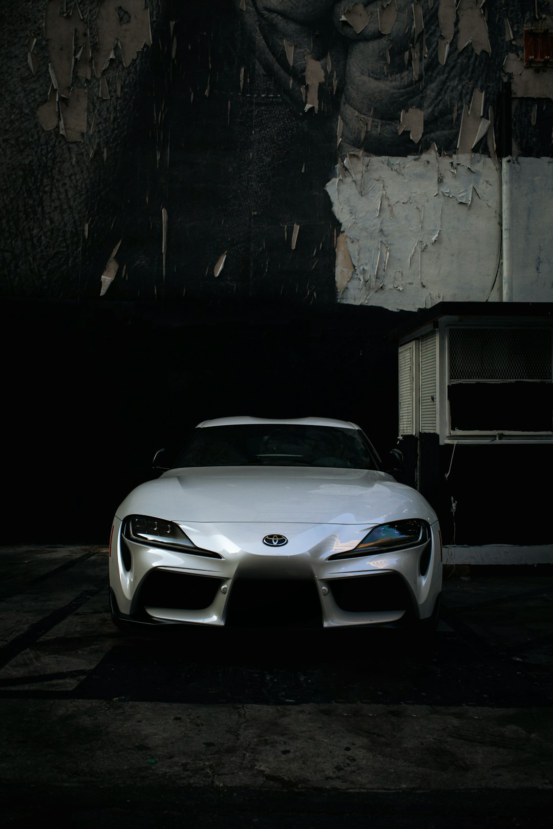 white bmw m 3 coupe parked beside gray concrete wall during nighttime