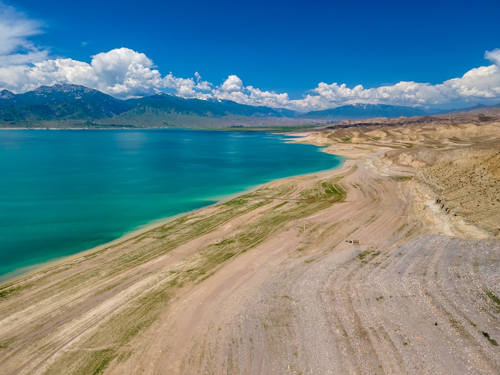 brown sand near body of water during daytime