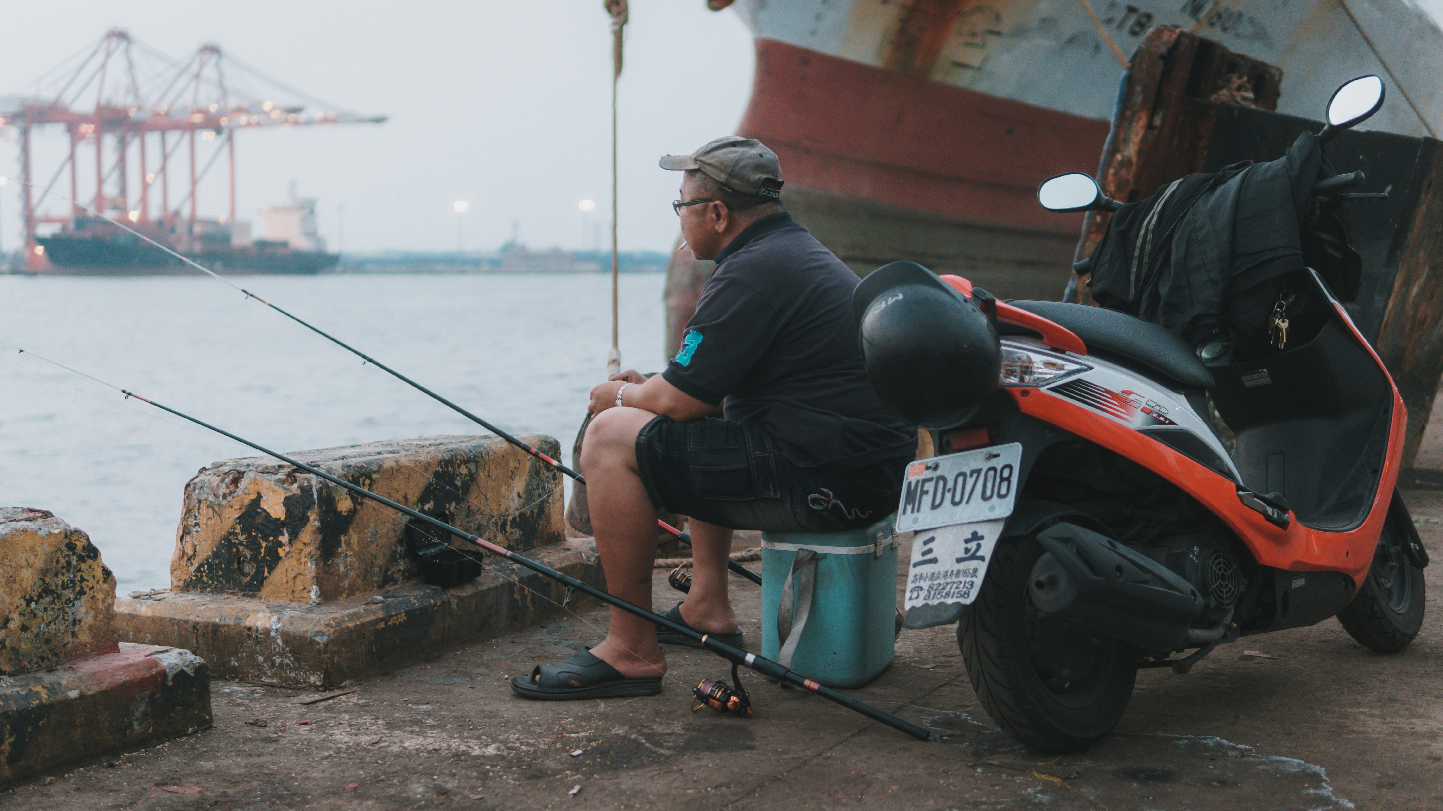 釣り竿を保持している黒のジャケットとブルーのデニム ジーンズの男の写真 Unsplashで見つける人の無料写真