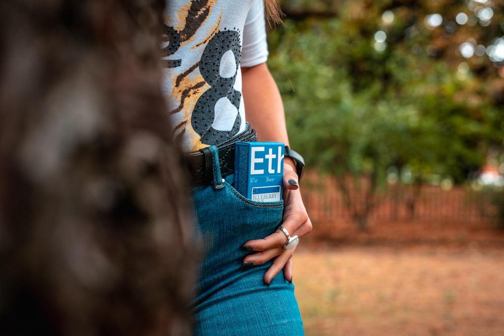 a woman is holding a cell phone in her pocket