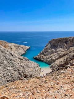aerial view of green and brown mountain beside blue sea during daytime