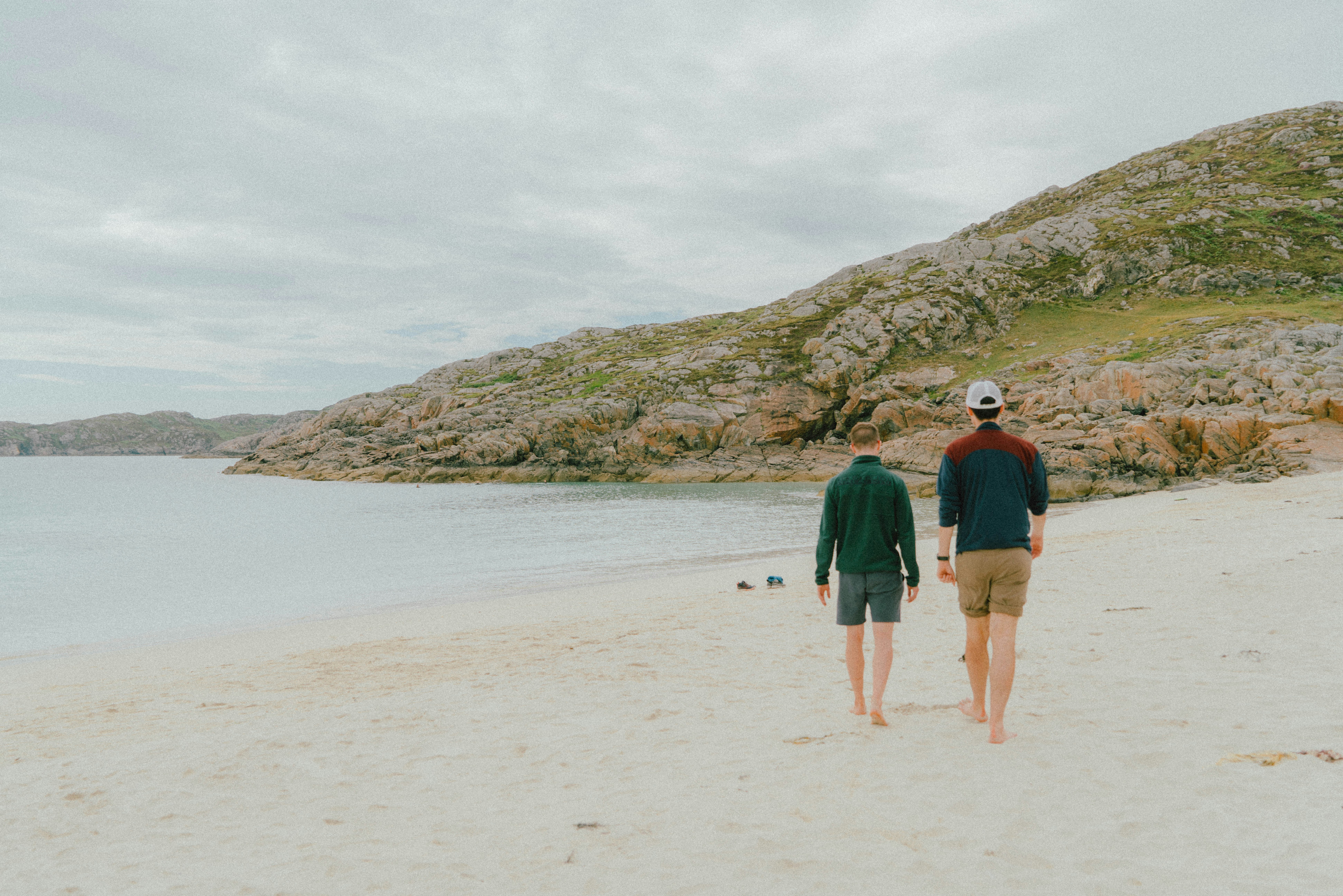 man and woman walking on beach during daytime