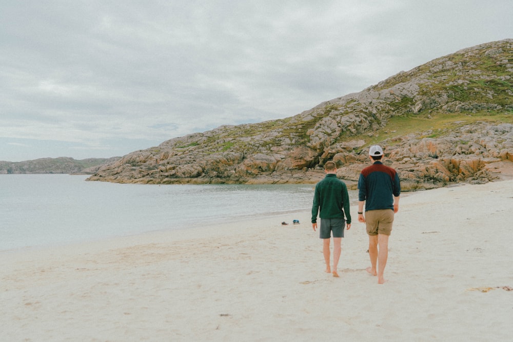 man and woman walking on beach during daytime