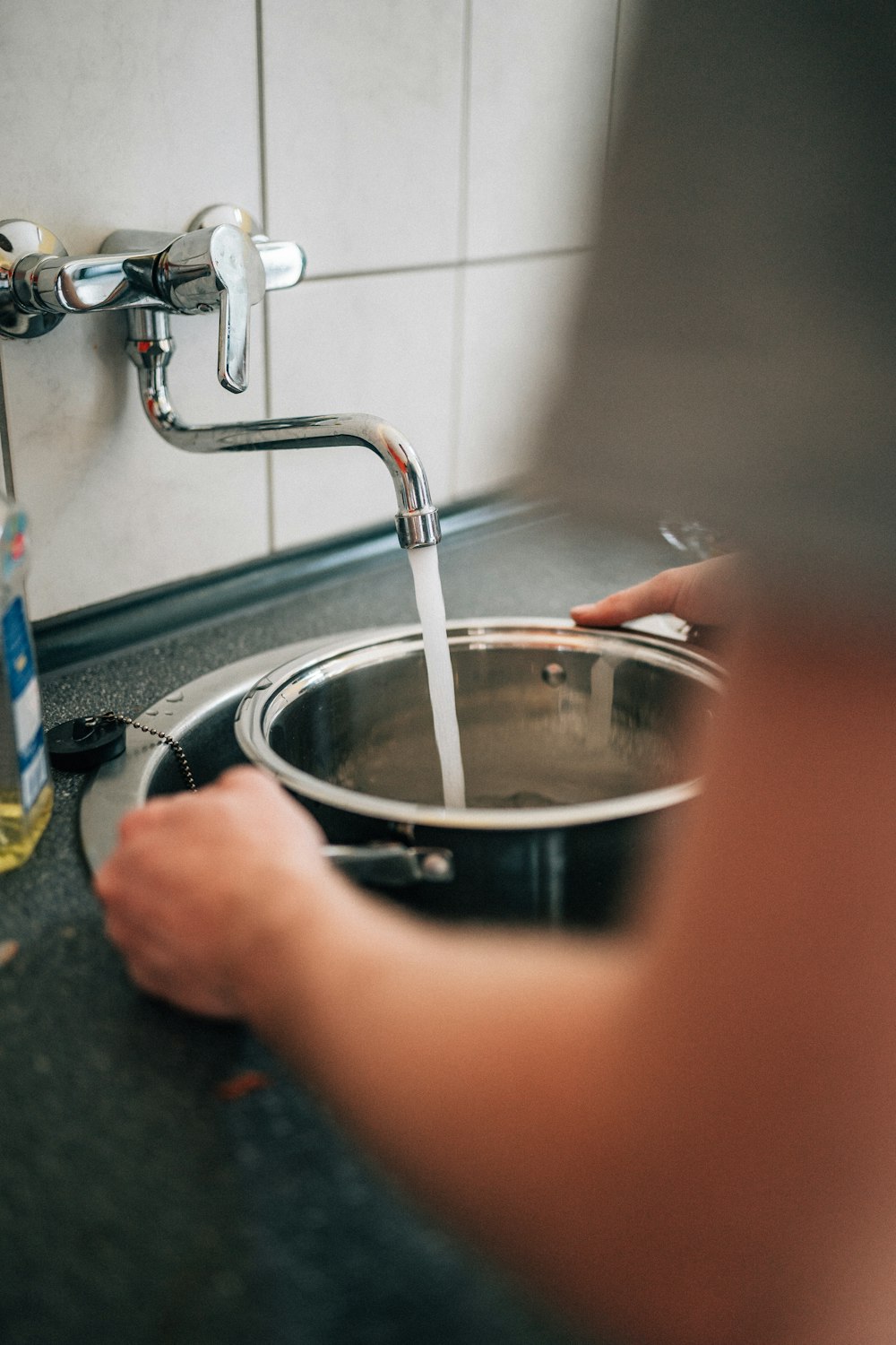 person washing stainless steel bowl