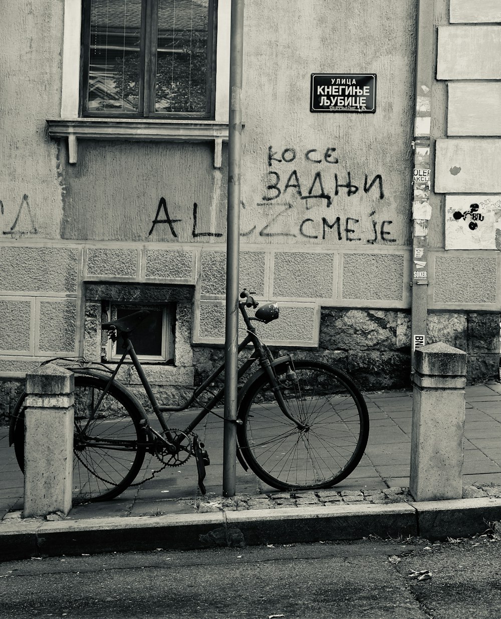 black bicycle parked beside wall