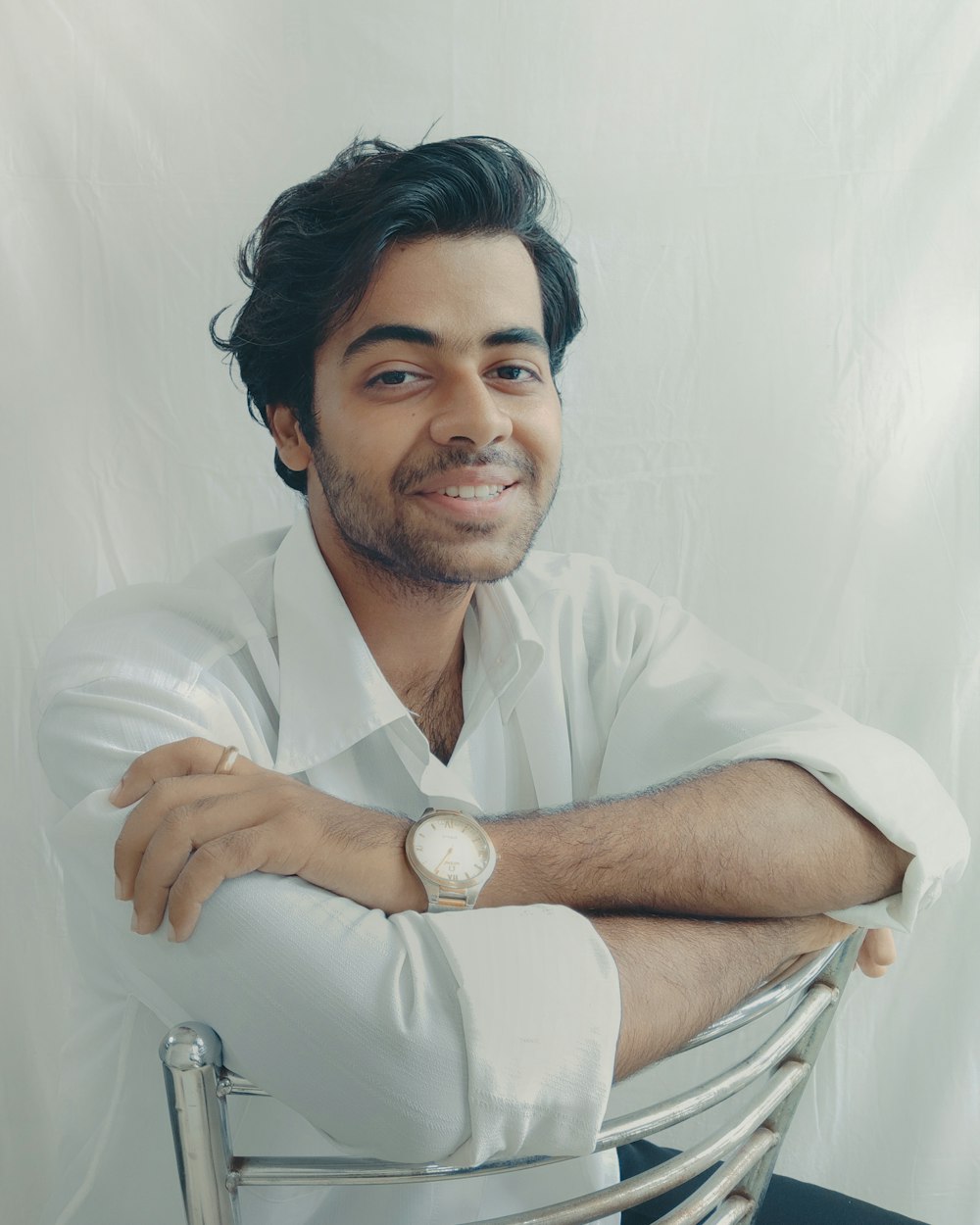 man in white button up shirt sitting on white chair