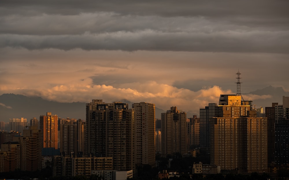 city skyline under cloudy sky during sunset