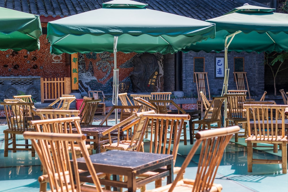 brown wooden table with chairs and green umbrella