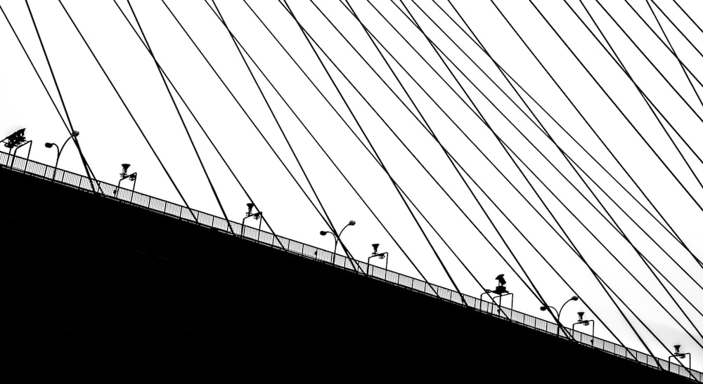 silhouette of people walking on bridge
