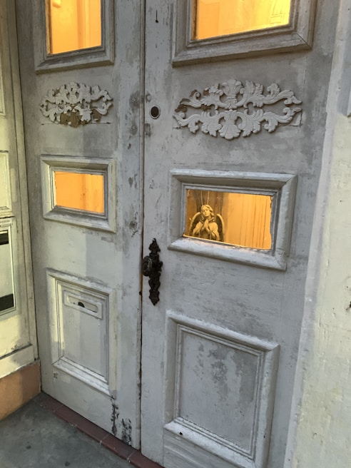 An elegant wooden door with intricate carvings and a brass handle, bathed in warm sunlight