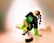 boy in black and green t-shirt and black pants sitting on floor