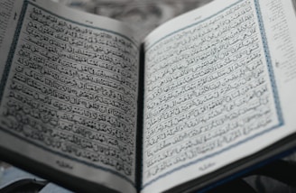 Open book with Arabic calligraphy and translation notes.