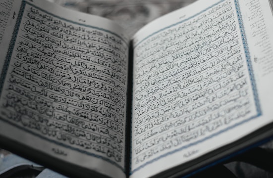 Open book with financial charts and Islamic motifs blending into the pages, symbolizing knowledge and faith.