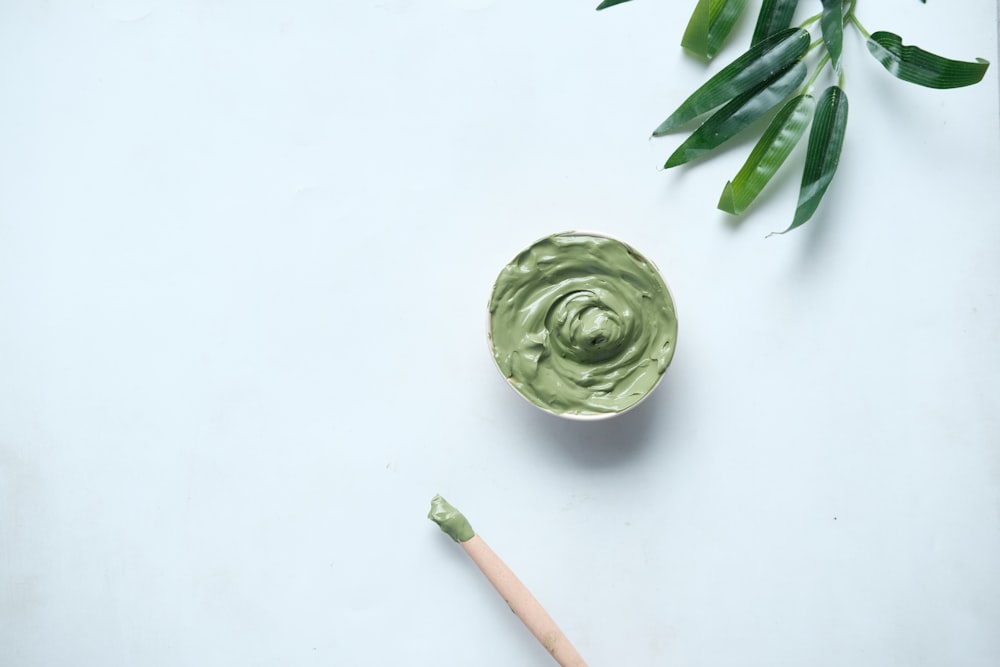 green ceramic round bowl on white table