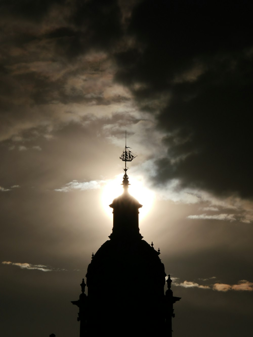 silhouette of cross under cloudy sky during daytime