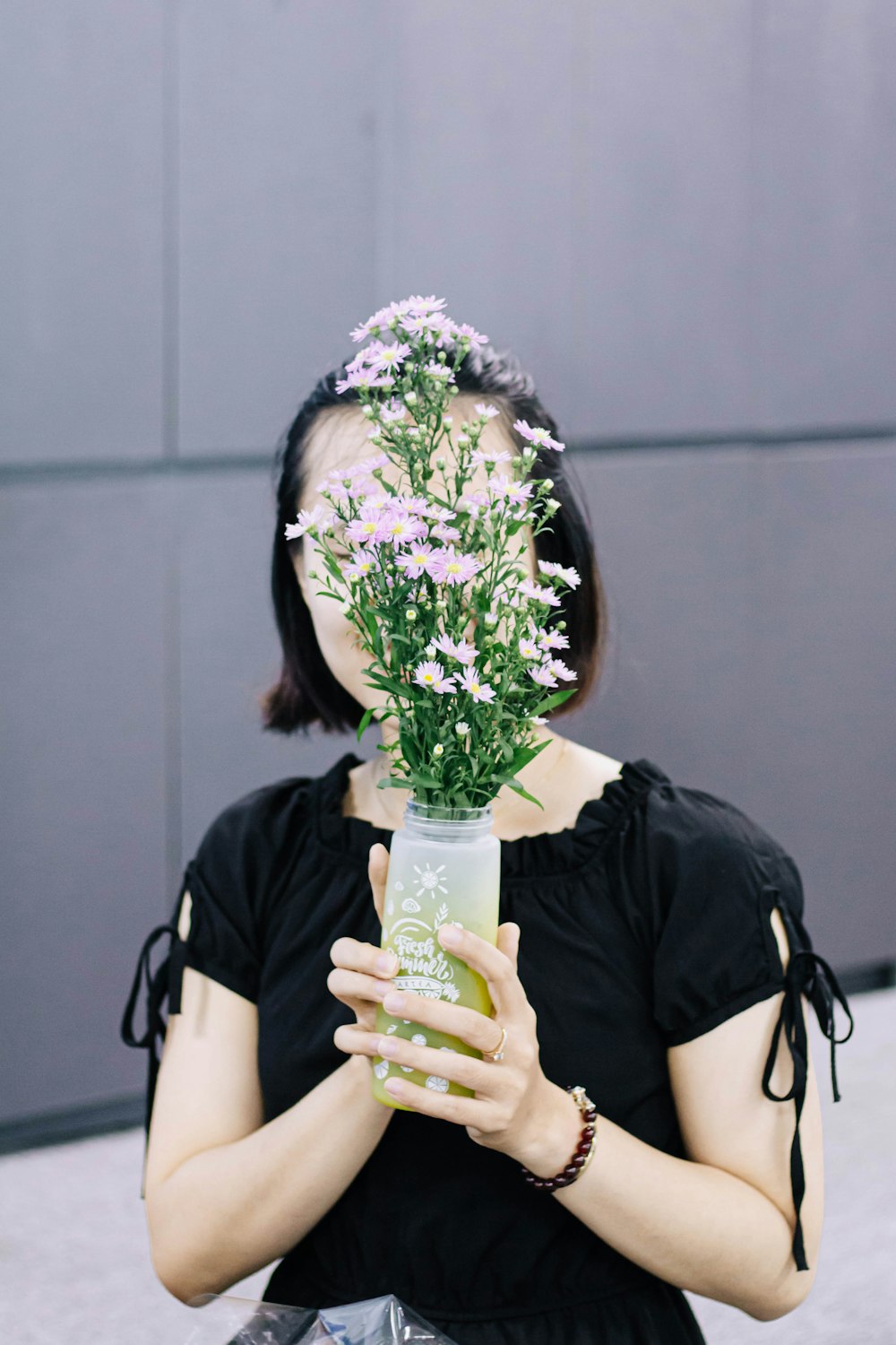 woman in black shirt holding bouquet of flowers
