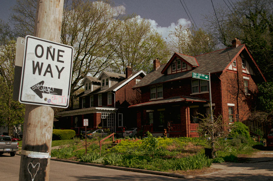 A One Way sign in front of brick houses