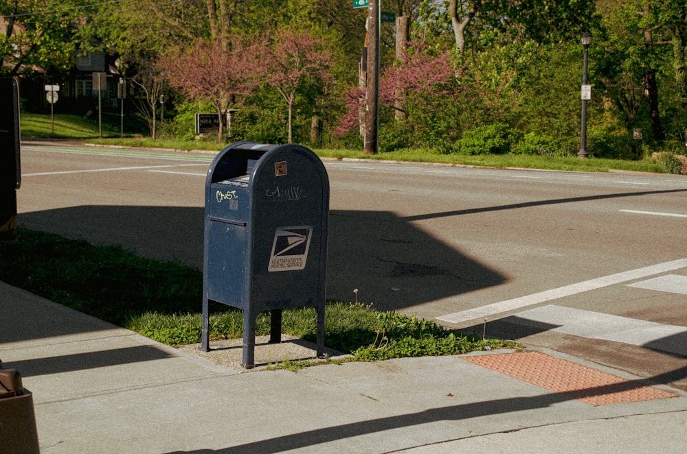 black mail box on gray asphalt road during daytime