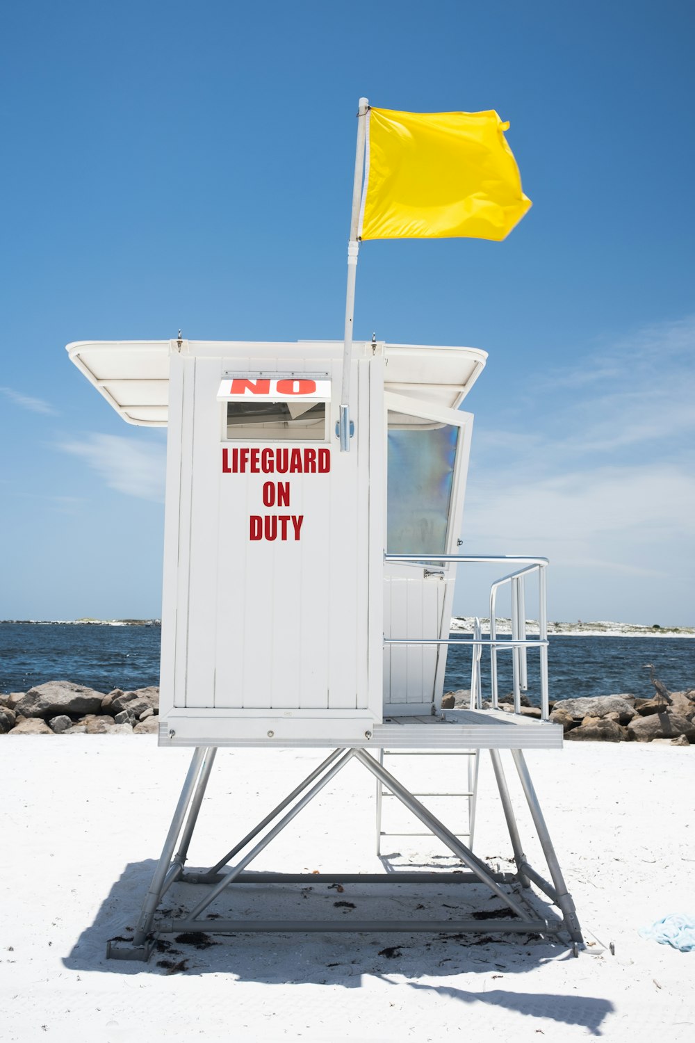 white lifeguard tower on beach during daytime