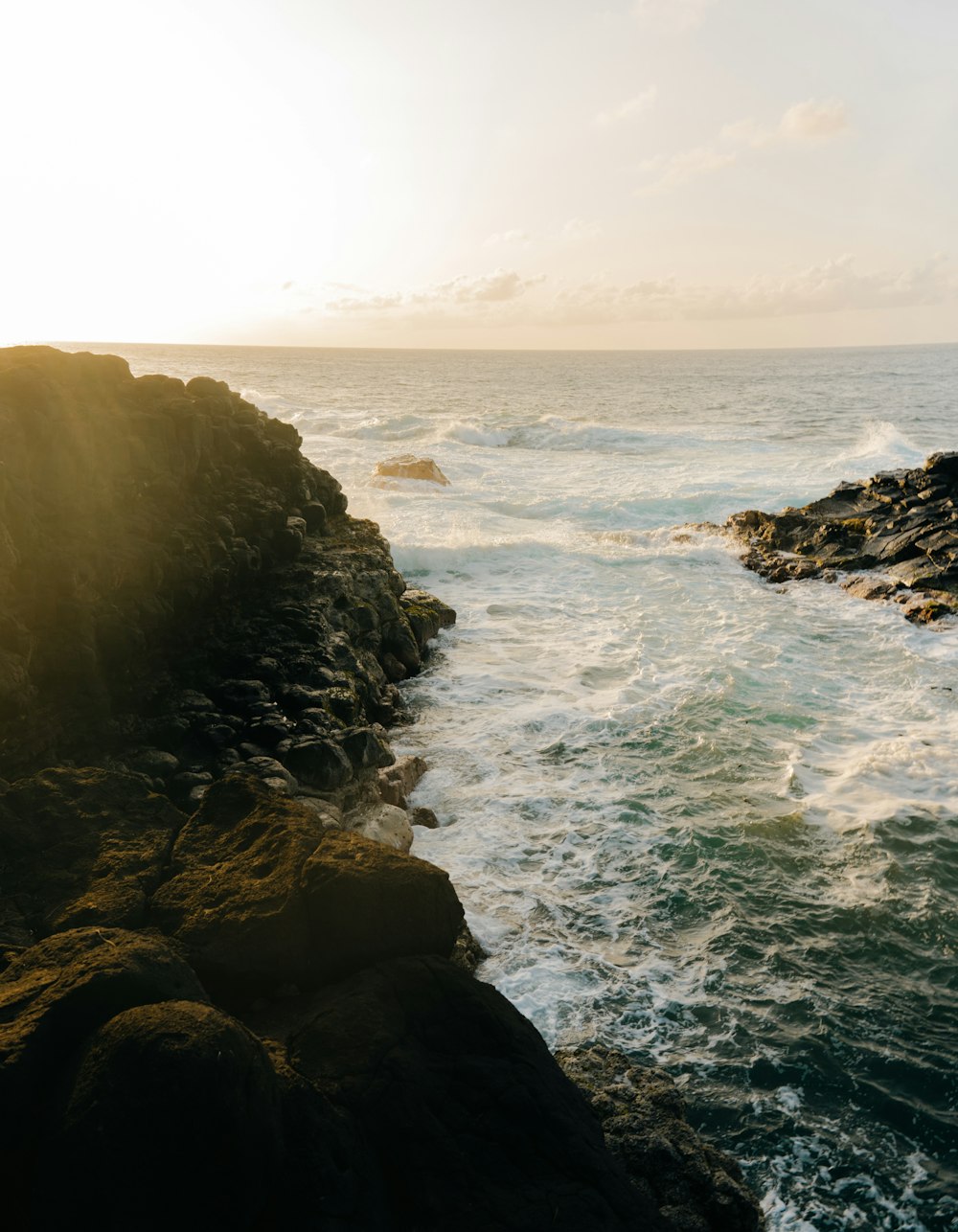 ocean waves crashing on rocky shore during daytime