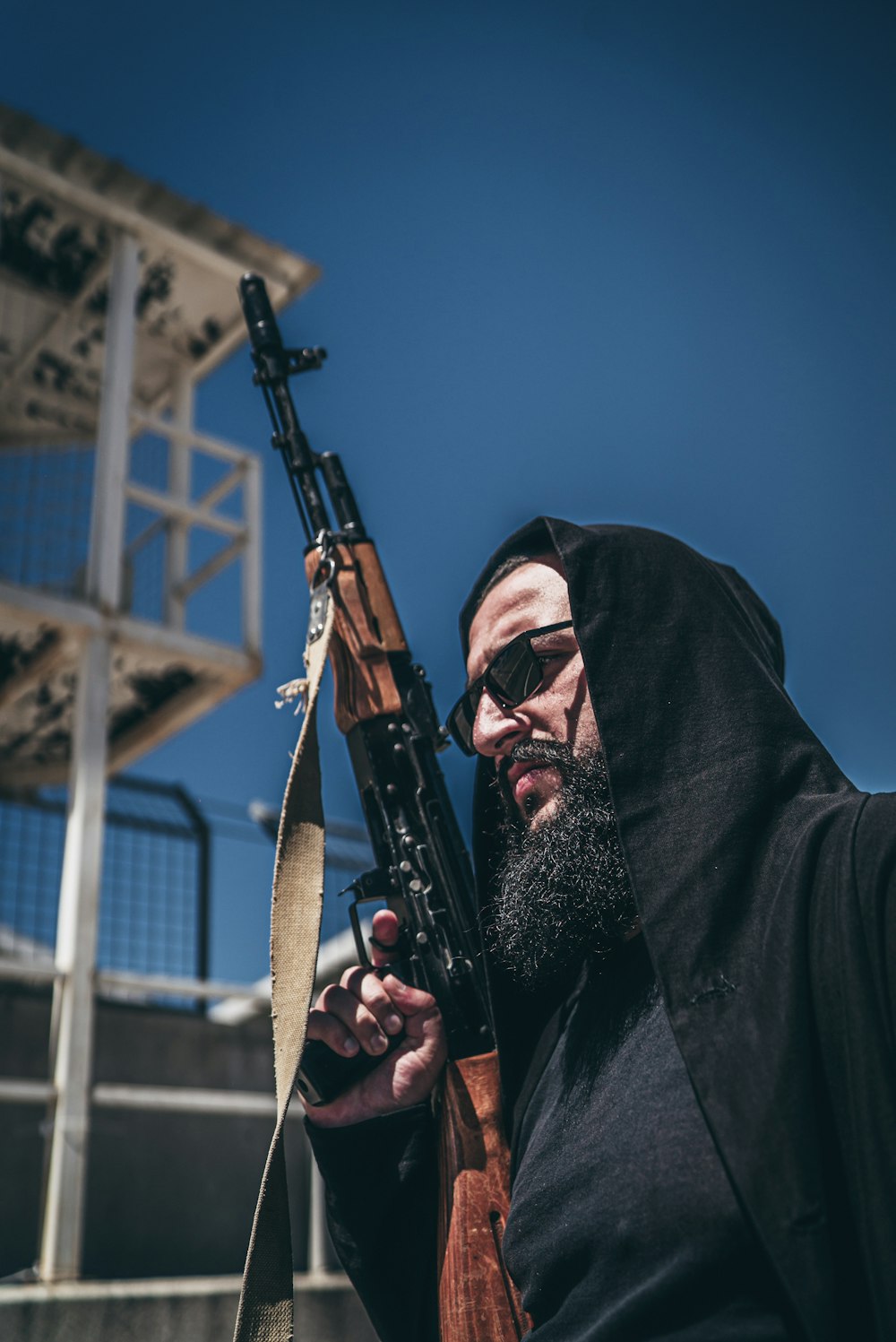 man in black coat holding black rifle