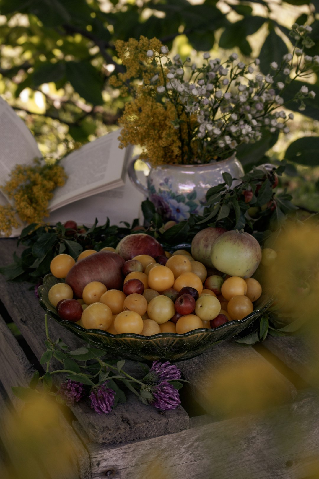 green and red round fruits on brown woven basket