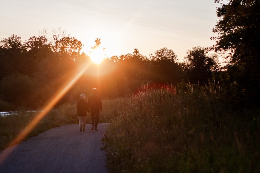 2 pessoas andando no caminho durante o pôr do sol