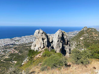 gray rocky mountain near body of water during daytime