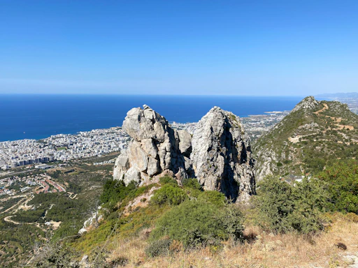 gray rocky mountain near body of water during daytime