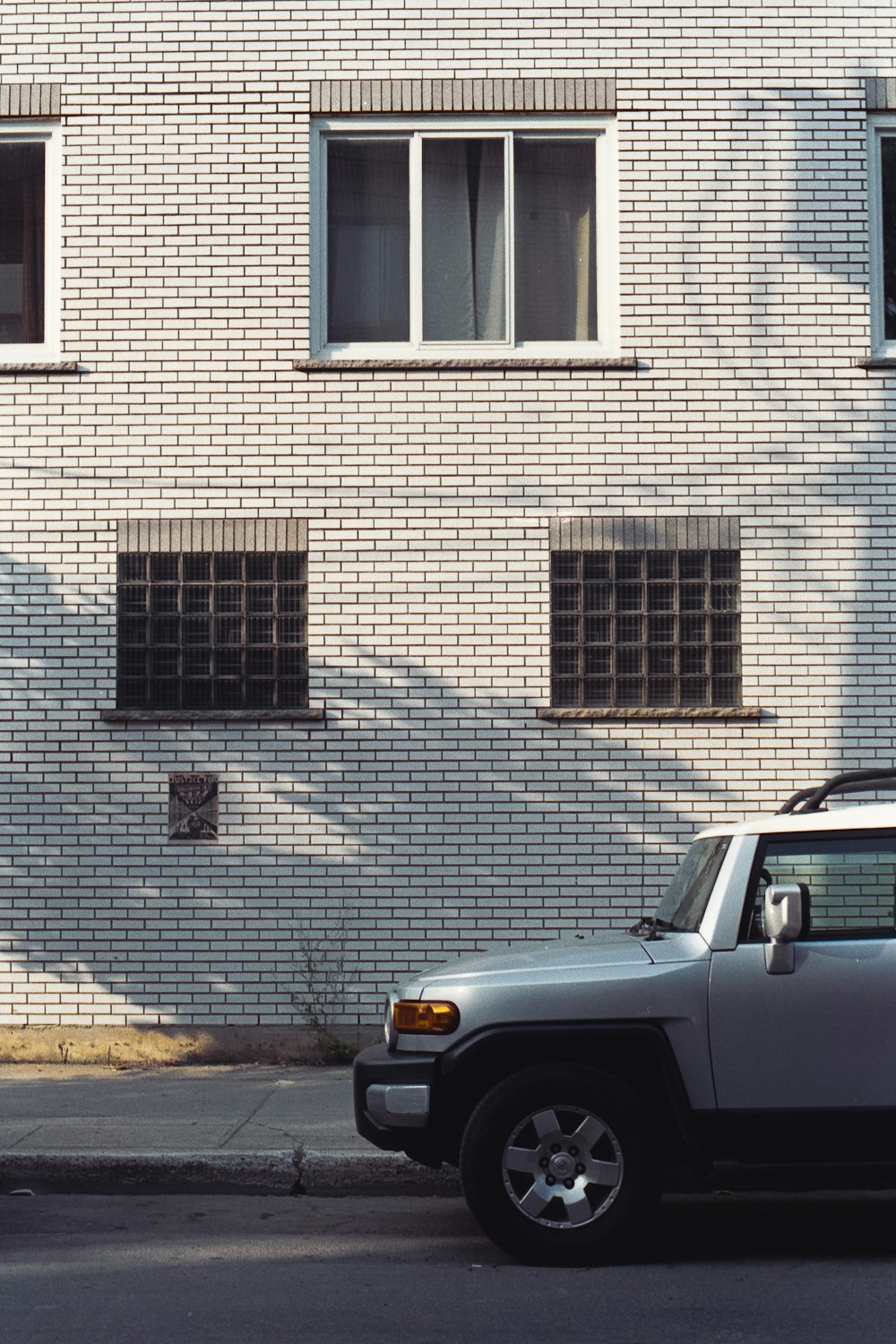 gray car parked beside brown brick building