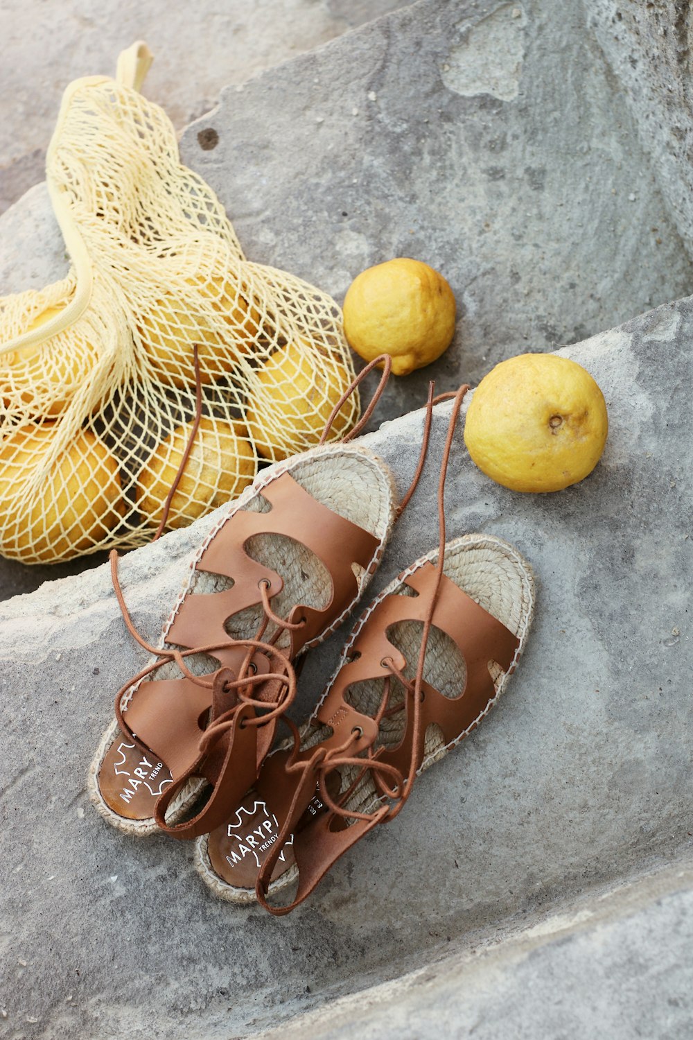 brown leather sandals beside yellow fruit