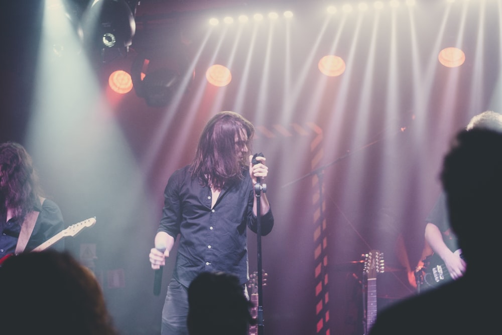 woman in blue denim jacket singing on stage