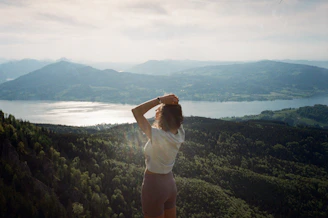 woman in white shirt standing on top of mountain during daytime