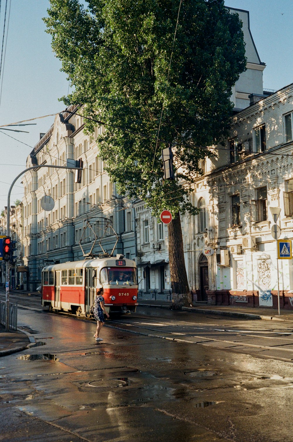 red tram on road near buildings during daytime