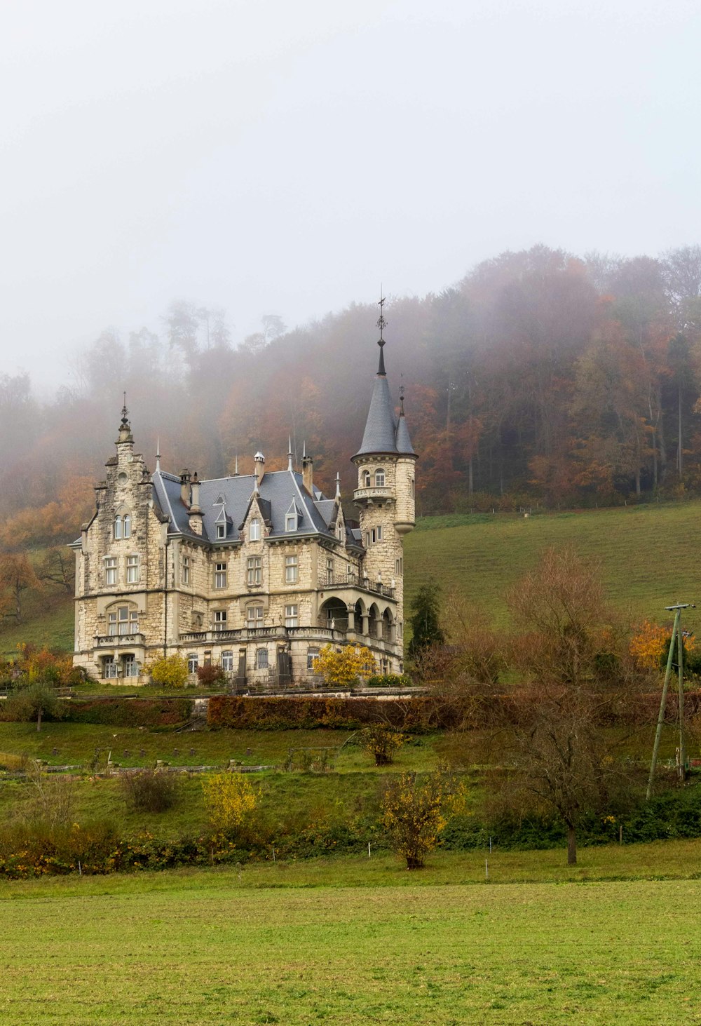 white and gray concrete castle surrounded by green trees during daytime