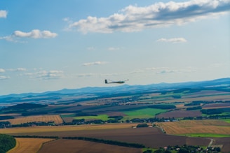 A character gliding with wings over a series of lush, floating islands under a bright sky.