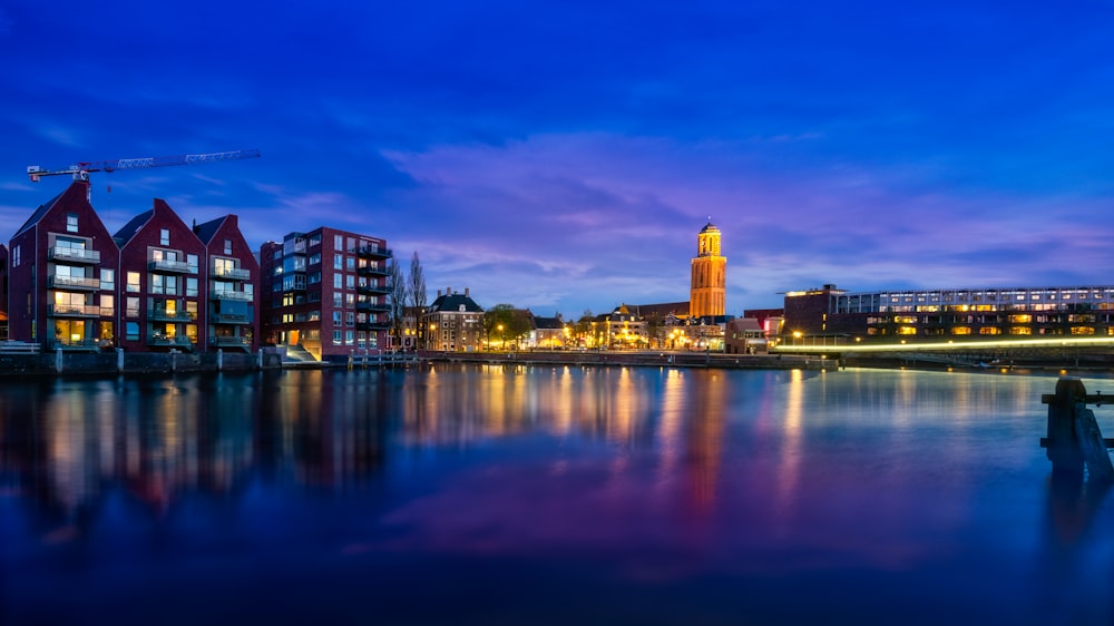 city skyline across body of water during night time