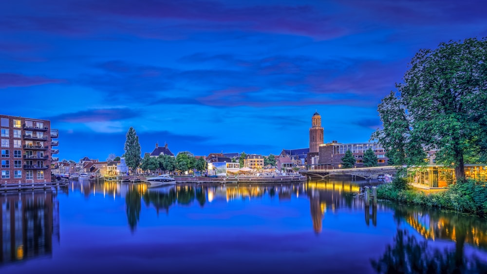 body of water near city buildings during night time