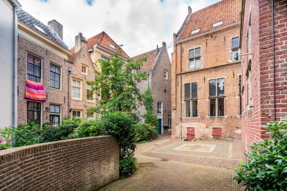 brown brick building near green trees under cloudy sky during daytime