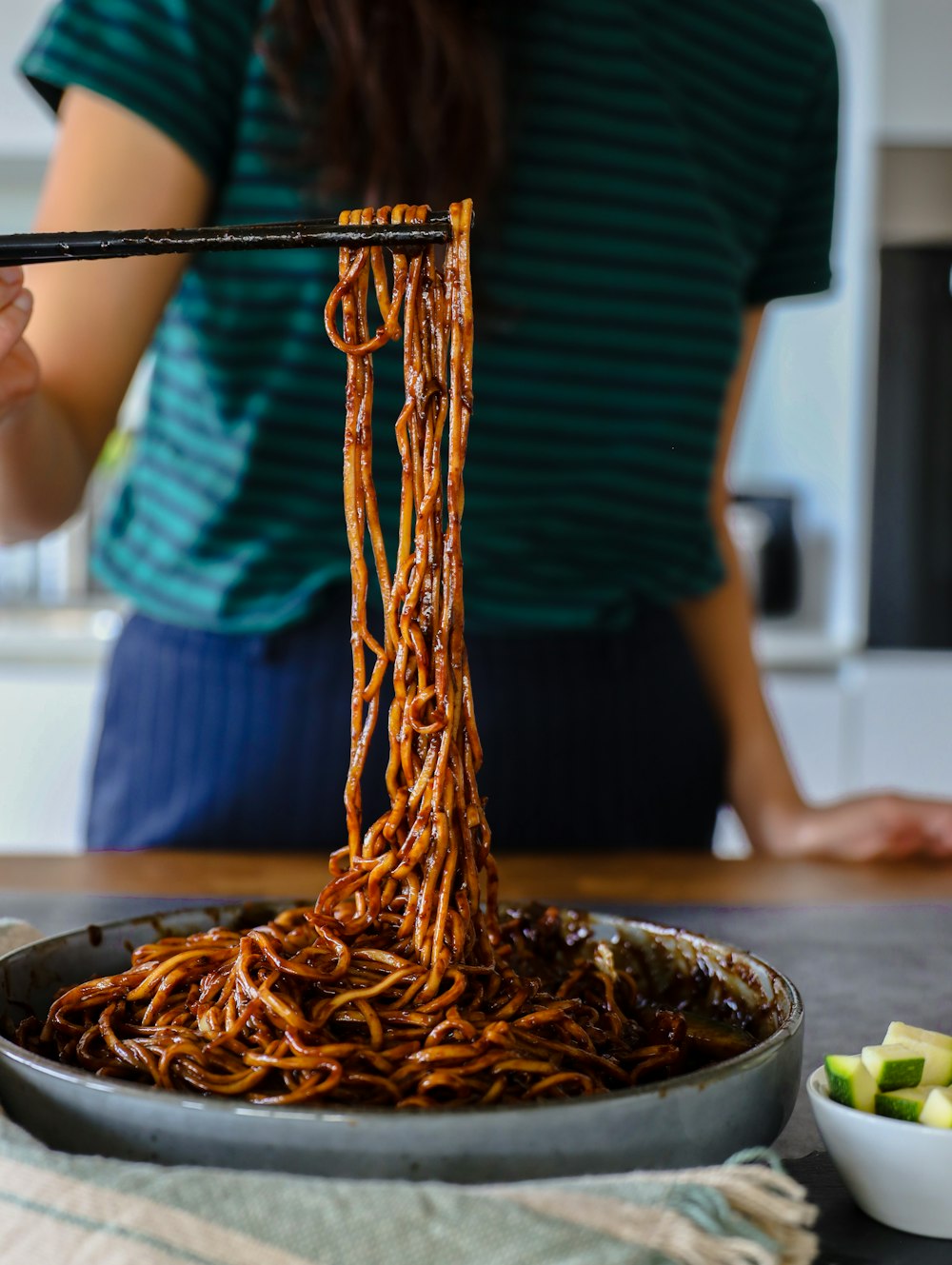 person in black shirt holding chopsticks