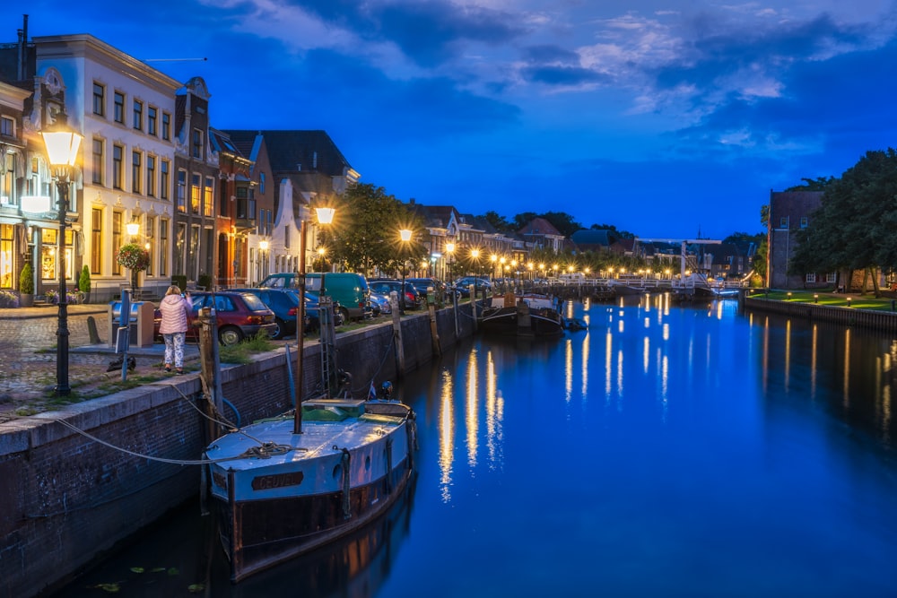 blue and white boat on dock during night time