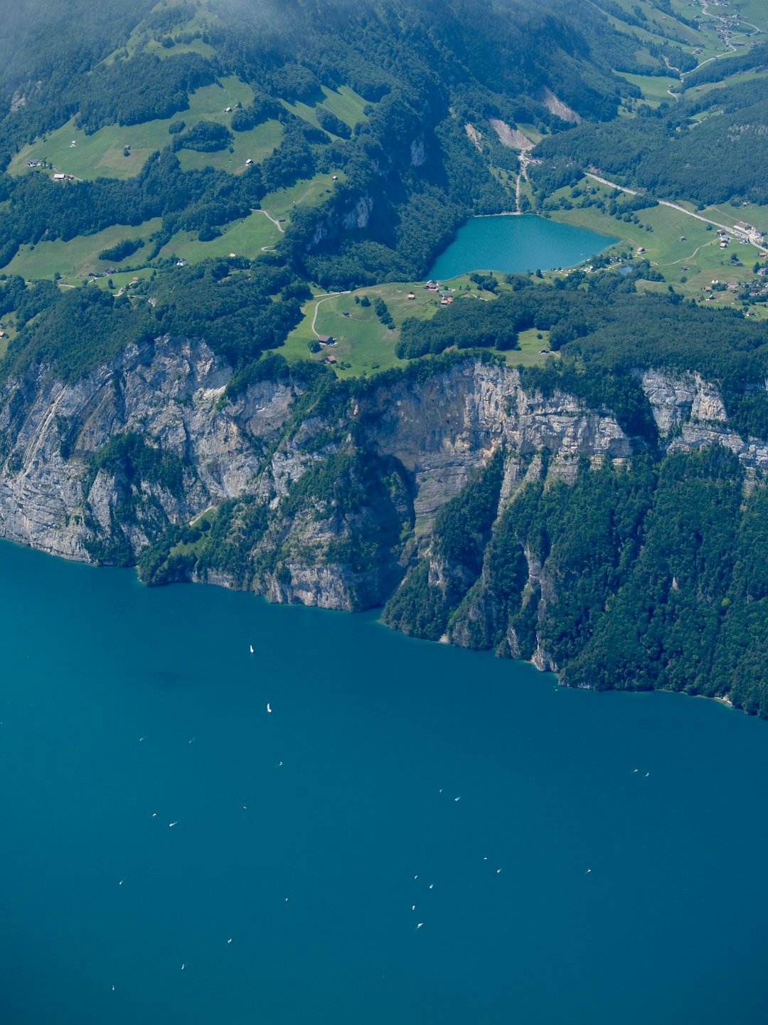 aerial view of green and brown mountain beside blue sea during daytime