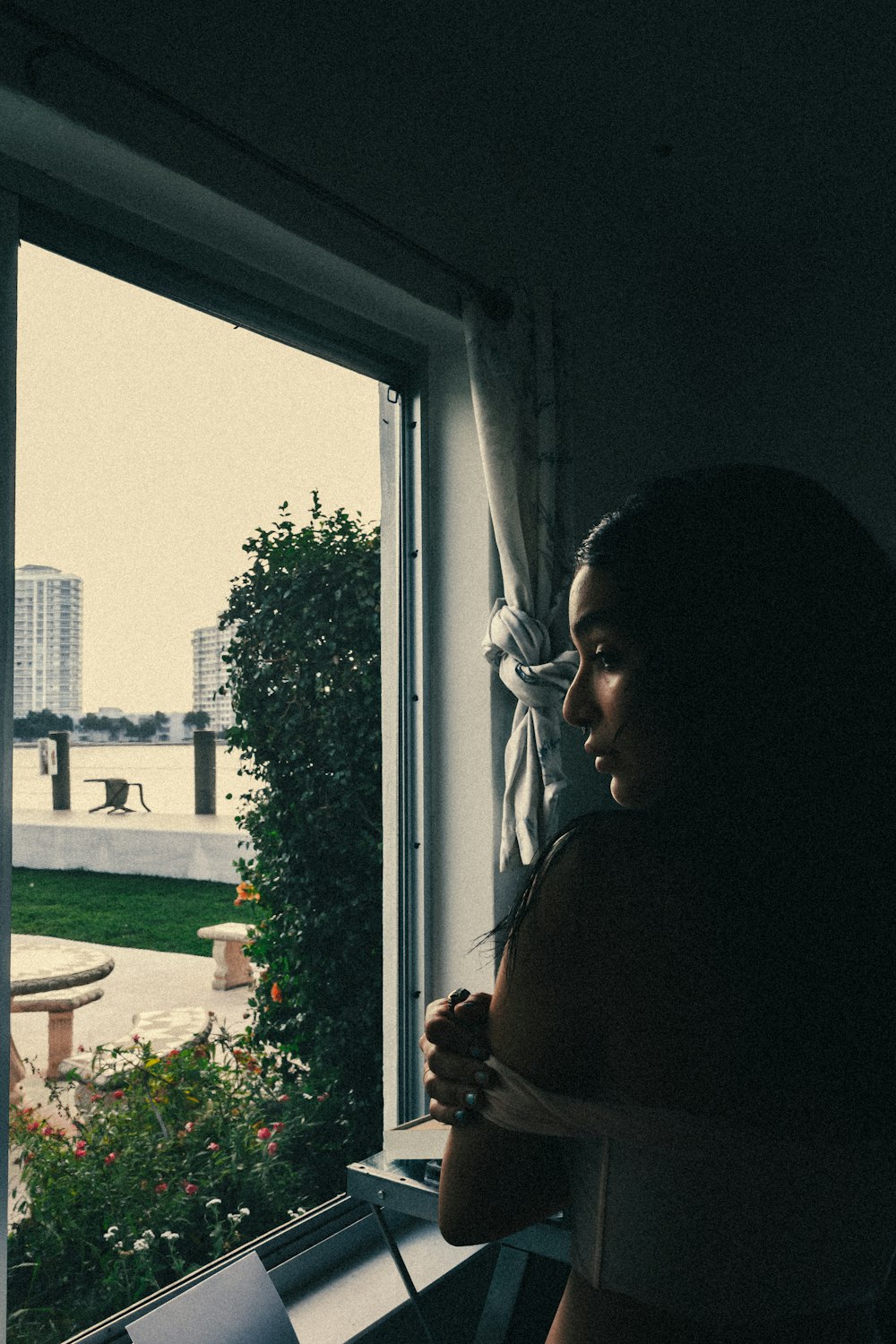 woman in black shirt standing near window